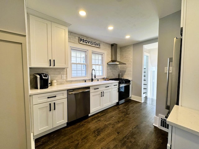 kitchen with stainless steel appliances, white cabinetry, backsplash, and wall chimney exhaust hood