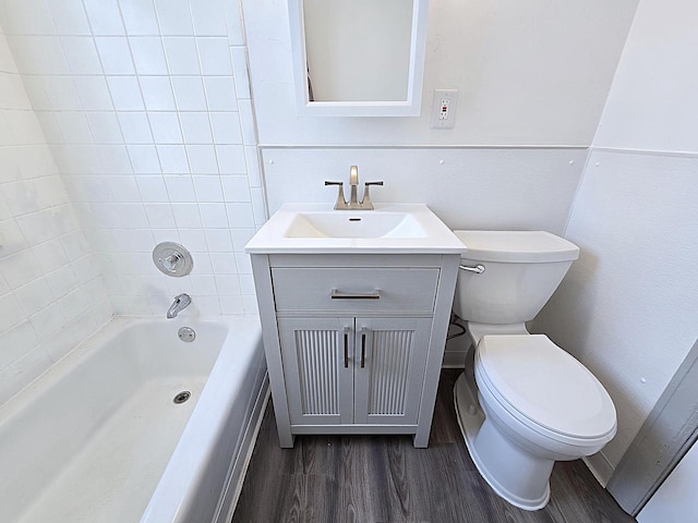 full bathroom with vanity, hardwood / wood-style floors, tub / shower combination, and toilet