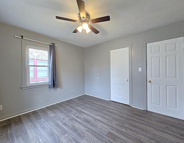 unfurnished bedroom with ceiling fan and dark hardwood / wood-style floors