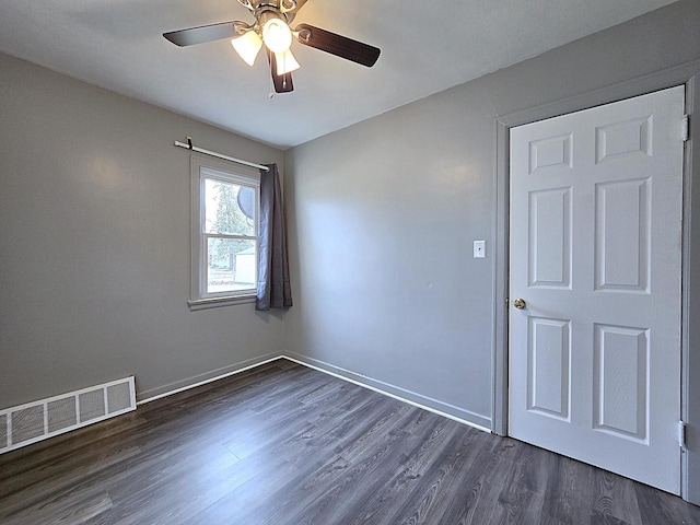 empty room featuring dark wood-type flooring and ceiling fan