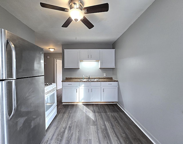 kitchen with sink, dark wood-type flooring, stainless steel refrigerator, white cabinets, and white gas range