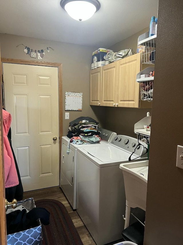 laundry area featuring dark wood-type flooring, cabinets, and washer and dryer