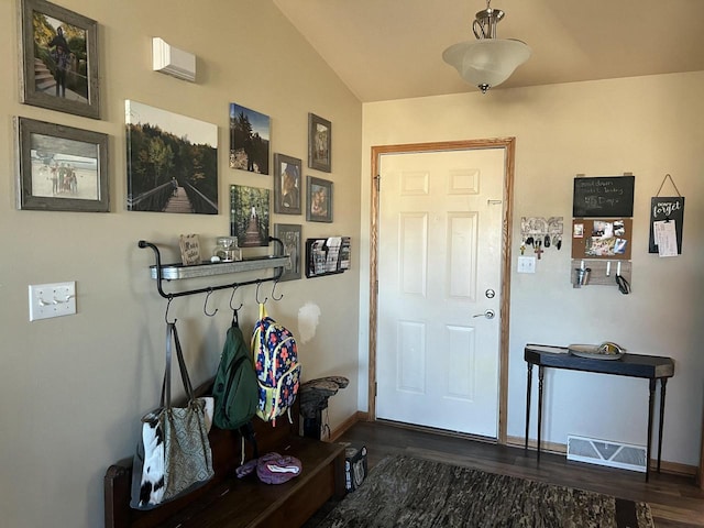 entryway with dark wood-type flooring and vaulted ceiling