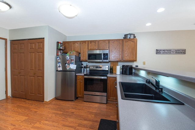 kitchen featuring sink, wood-type flooring, and appliances with stainless steel finishes