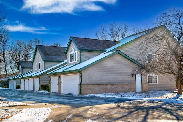 view of snowy exterior featuring a garage