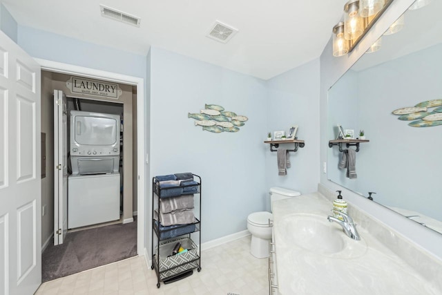 bathroom with stacked washing maching and dryer, vanity, and toilet