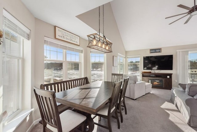 carpeted dining room featuring ceiling fan and high vaulted ceiling