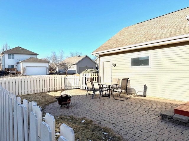 view of patio / terrace with a garage and an outdoor fire pit