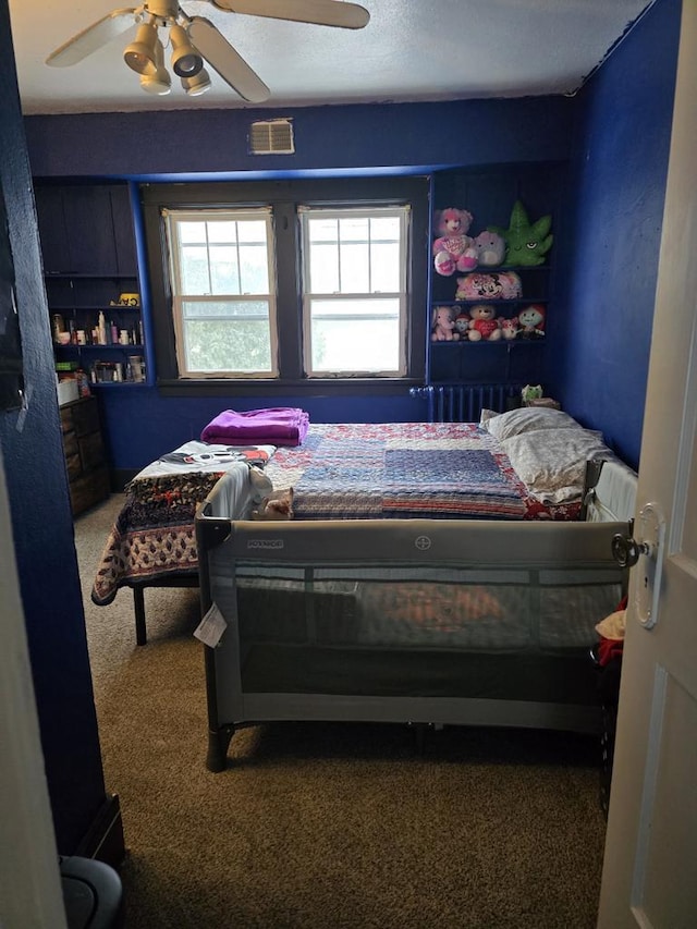 carpeted bedroom featuring multiple windows and ceiling fan