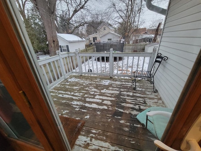 snow covered deck featuring an outbuilding