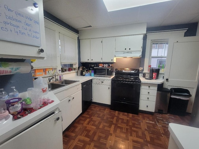 kitchen featuring dark parquet flooring, sink, black appliances, white cabinets, and a drop ceiling