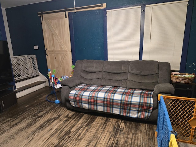 living room with a barn door and dark hardwood / wood-style floors