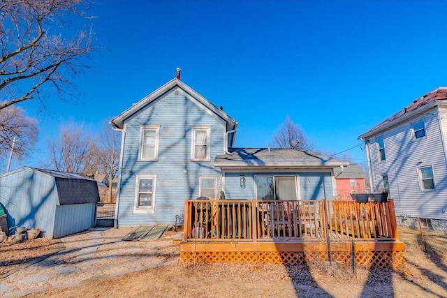 rear view of house featuring a wooden deck and a shed