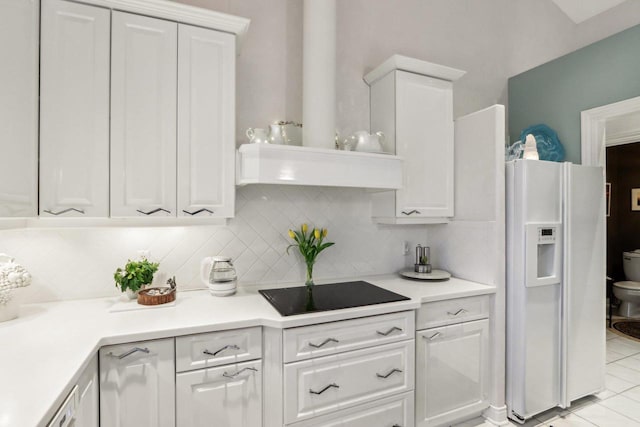 kitchen with tasteful backsplash, white cabinets, white refrigerator with ice dispenser, black electric stovetop, and wall chimney range hood