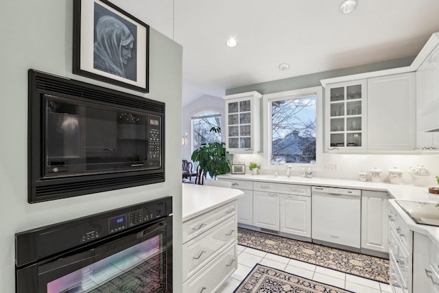 kitchen with white cabinetry, sink, light tile patterned floors, and black appliances