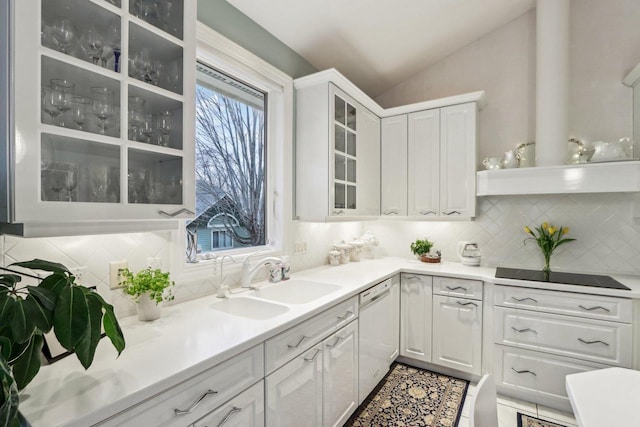 kitchen featuring lofted ceiling, sink, white dishwasher, black electric stovetop, and white cabinets