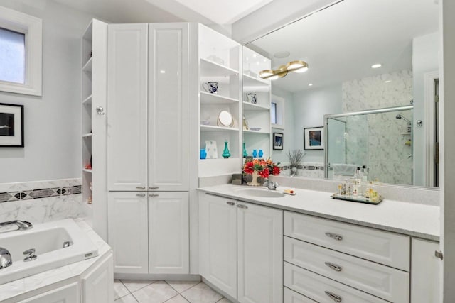 bathroom featuring independent shower and bath, vanity, and tile patterned flooring