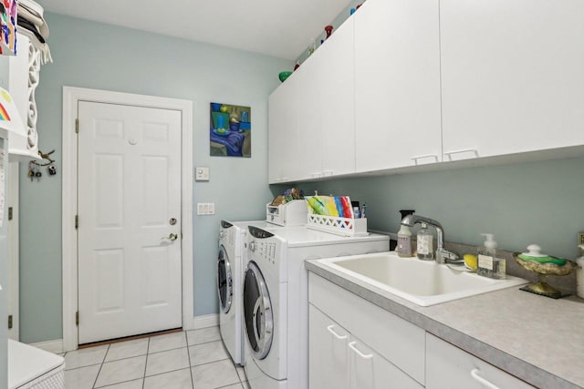 clothes washing area featuring sink, independent washer and dryer, light tile patterned floors, and cabinets