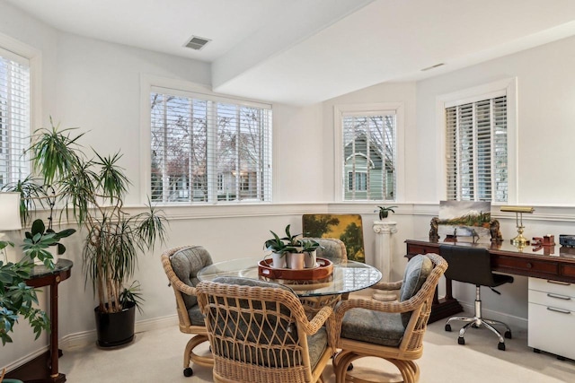 dining space featuring plenty of natural light and light carpet