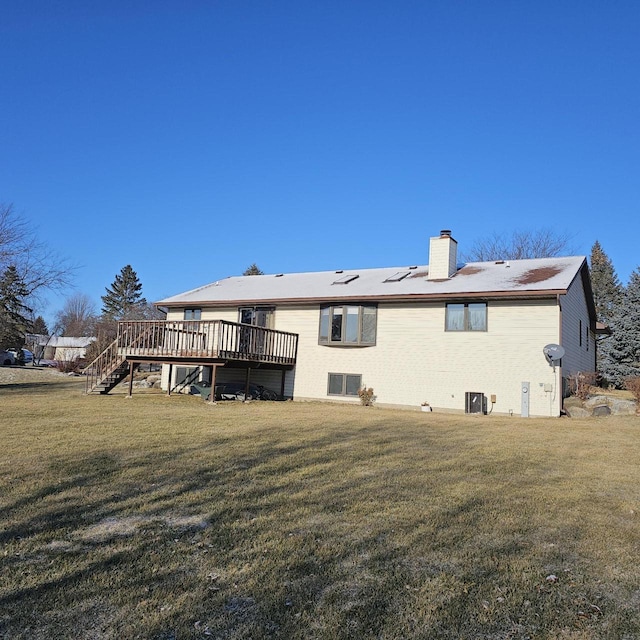 back of property featuring central AC unit, a deck, and a lawn