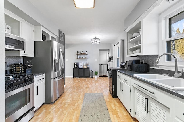 kitchen featuring stainless steel appliances, sink, light hardwood / wood-style flooring, and white cabinets