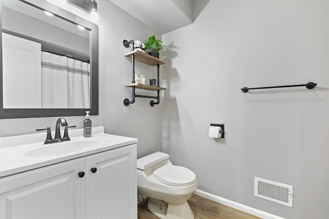 bathroom featuring hardwood / wood-style flooring, vanity, toilet, and a shower with shower curtain