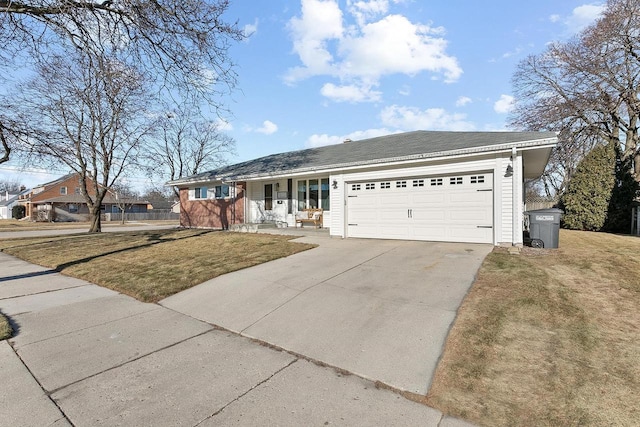 ranch-style home featuring a garage, covered porch, and a front yard