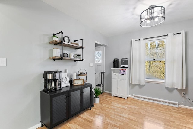 interior space with plenty of natural light, a notable chandelier, and light hardwood / wood-style flooring