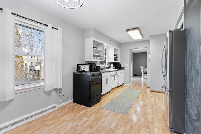 kitchen featuring white cabinetry, a baseboard heating unit, sink, and stainless steel refrigerator