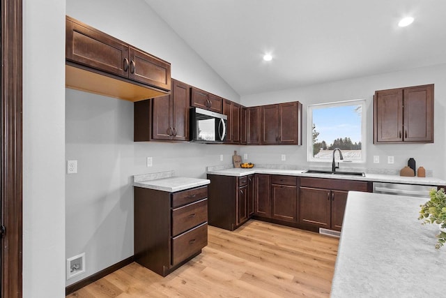 kitchen featuring lofted ceiling, sink, light hardwood / wood-style flooring, and stainless steel appliances