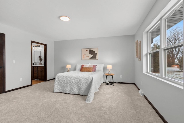 carpeted bedroom with sink and ensuite bathroom