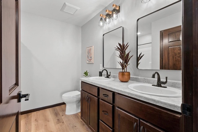 bathroom featuring wood-type flooring, toilet, and vanity