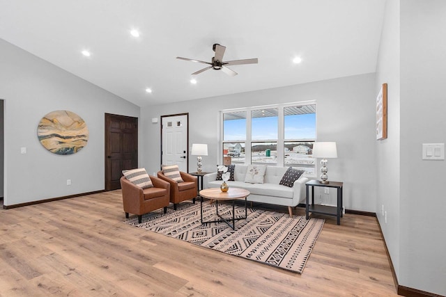 living room with ceiling fan, lofted ceiling, and light hardwood / wood-style flooring