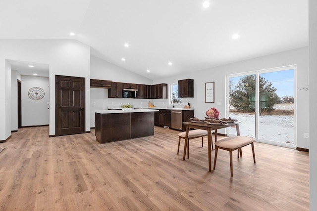 kitchen with sink, stainless steel appliances, a center island, dark brown cabinetry, and light hardwood / wood-style floors