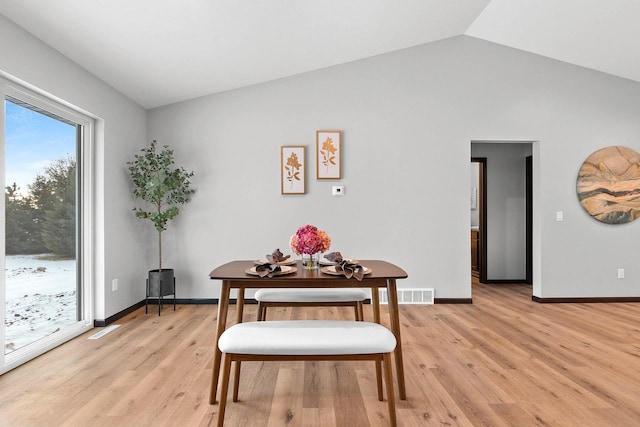 dining area with lofted ceiling and light wood-type flooring