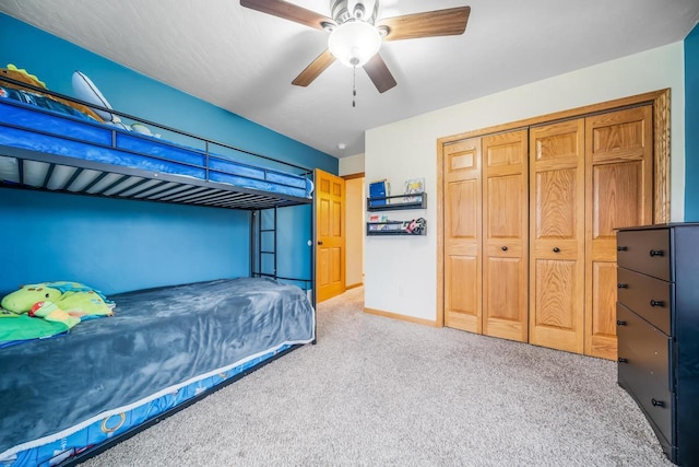 bedroom with ceiling fan, a closet, and light carpet