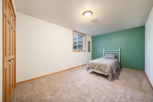 carpeted bedroom with a textured ceiling