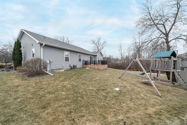 view of yard featuring central AC unit, a playground, and a deck