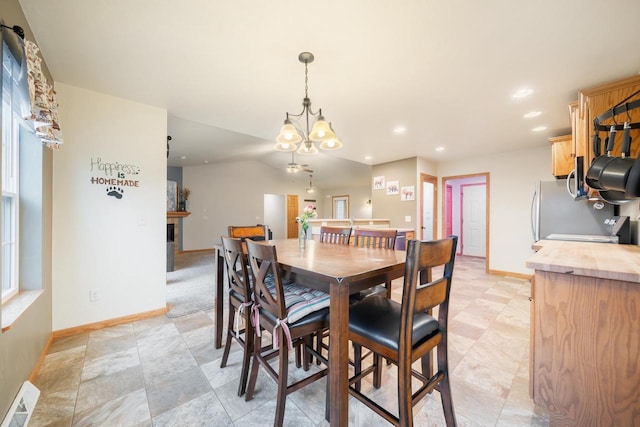 dining room with lofted ceiling, plenty of natural light, and a chandelier