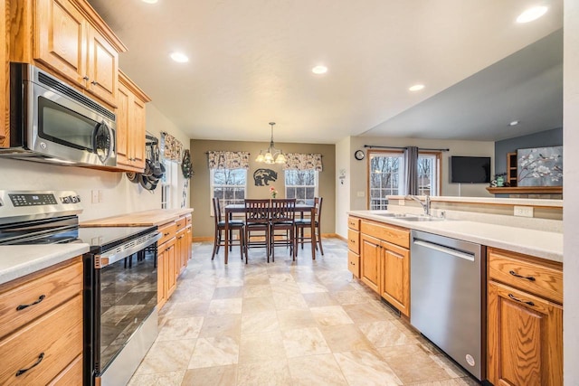 kitchen featuring an inviting chandelier, sink, decorative light fixtures, and stainless steel appliances