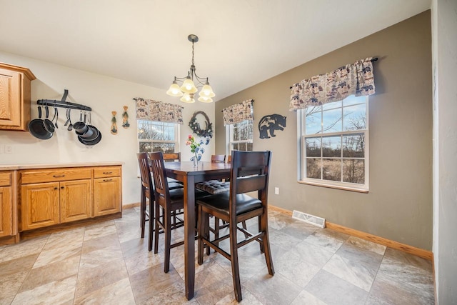 dining space featuring a healthy amount of sunlight and a chandelier