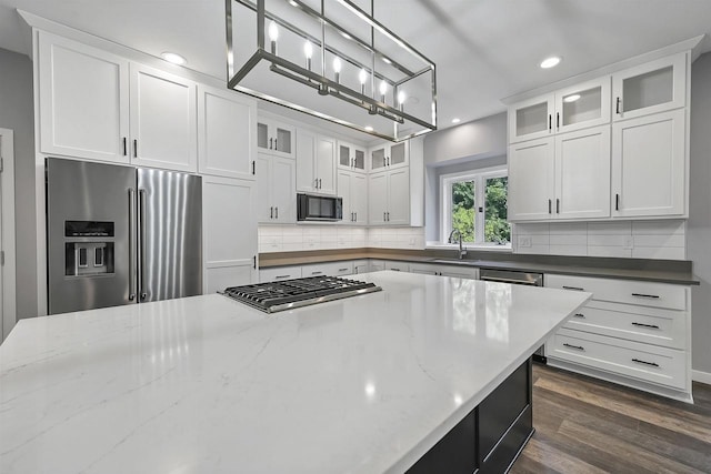 kitchen with stainless steel appliances, white cabinetry, and pendant lighting