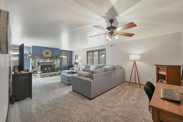 carpeted living room with a fireplace and ceiling fan