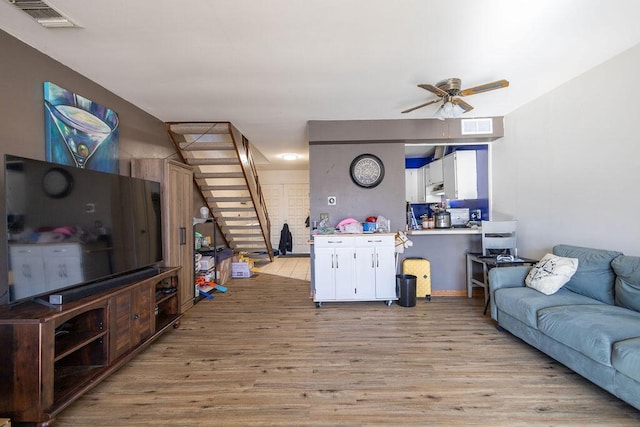 living room featuring ceiling fan and light hardwood / wood-style flooring