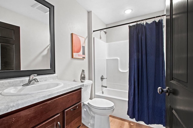 full bathroom with vanity, wood-type flooring, shower / bath combo with shower curtain, and toilet