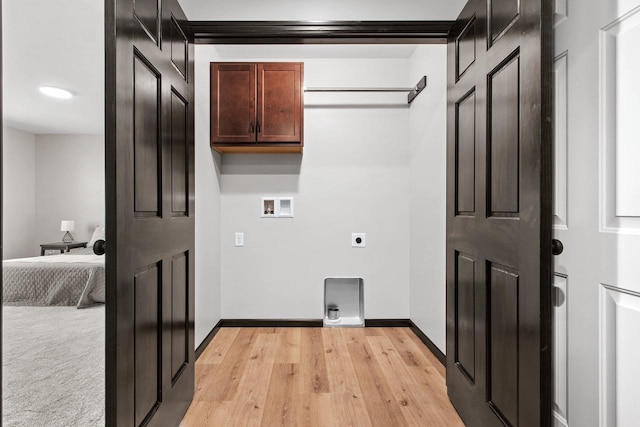 clothes washing area with electric dryer hookup, washer hookup, and light wood-type flooring