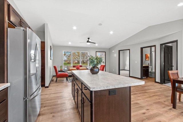 kitchen with a kitchen island, lofted ceiling, light wood-type flooring, and stainless steel fridge with ice dispenser