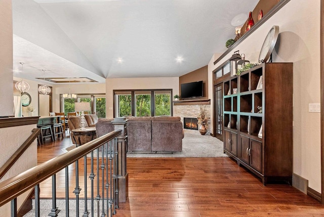 living room featuring dark hardwood / wood-style flooring, lofted ceiling, and a fireplace