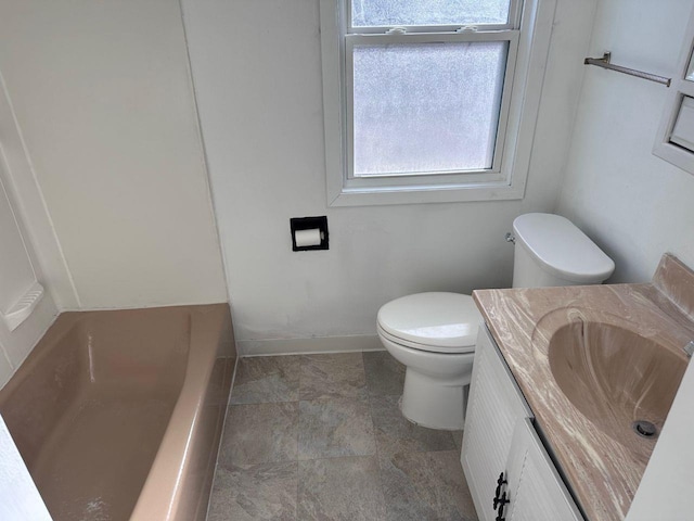 bathroom with vanity, a bathing tub, and toilet