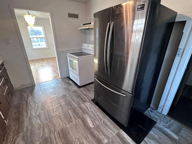 kitchen featuring stainless steel refrigerator, white cabinetry, and white electric range oven